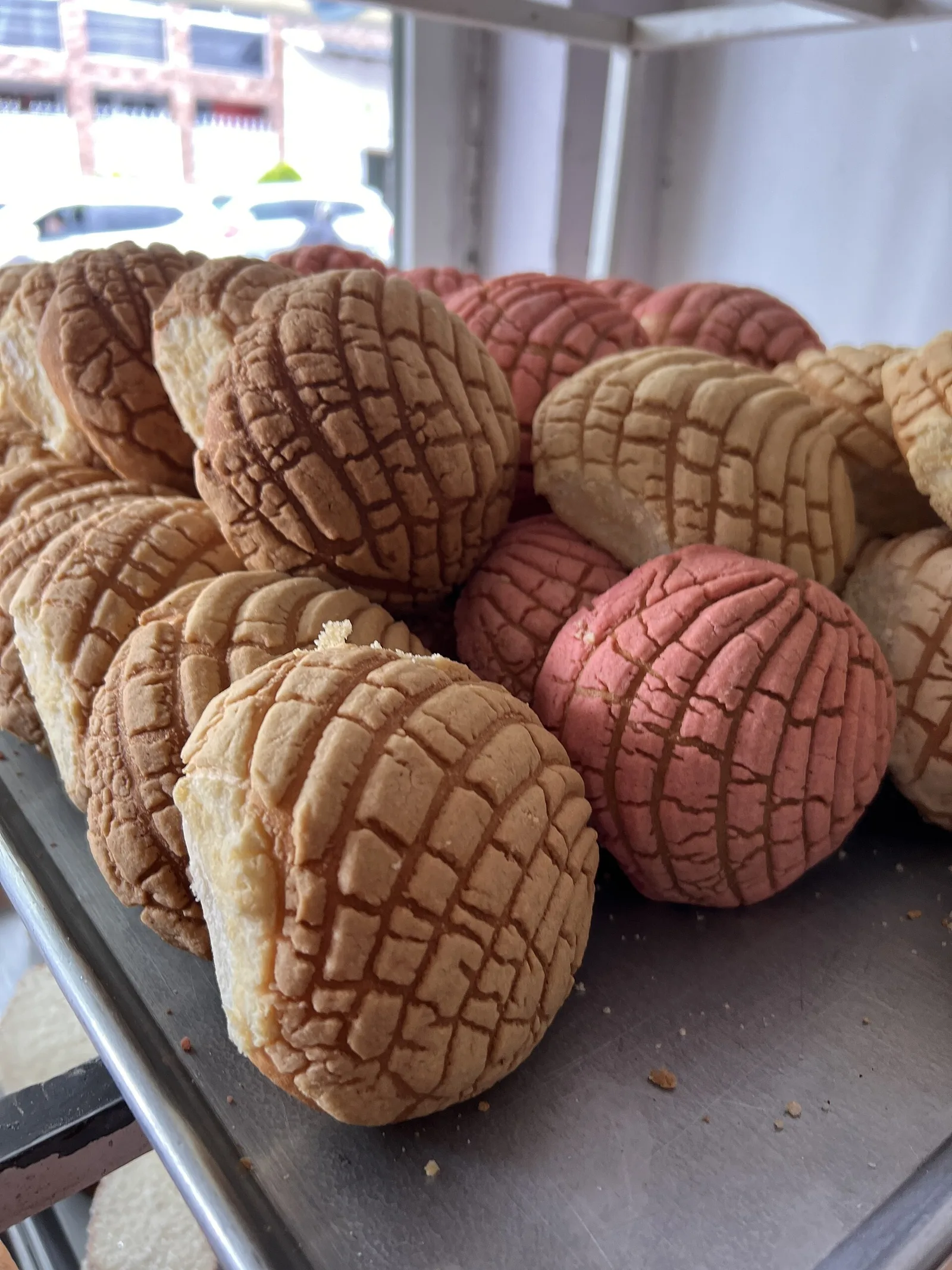 Conchas, a Mexican sweet bread, on a bakery tray. The photo was not taken at any bakery on this list.