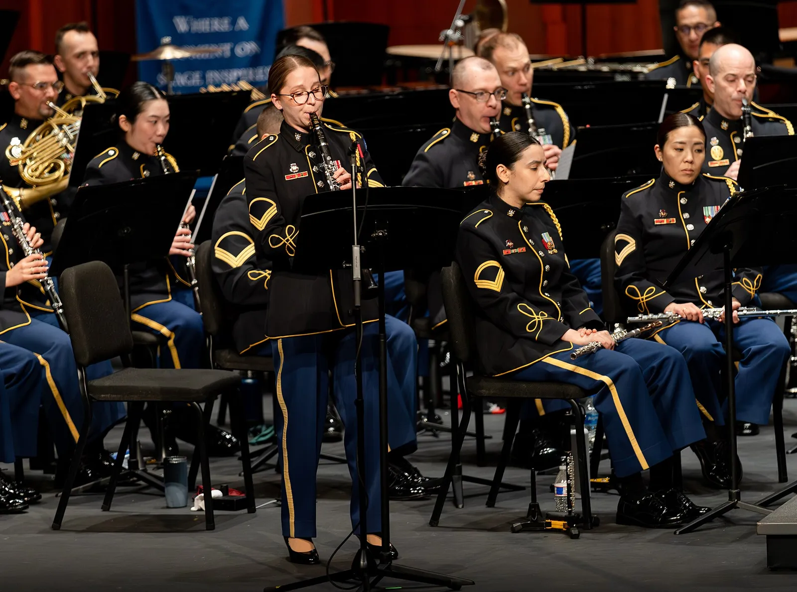 A clarinet soloist performs with a concert band on the stage of the Hylton Performing Arts Center in Manassas.