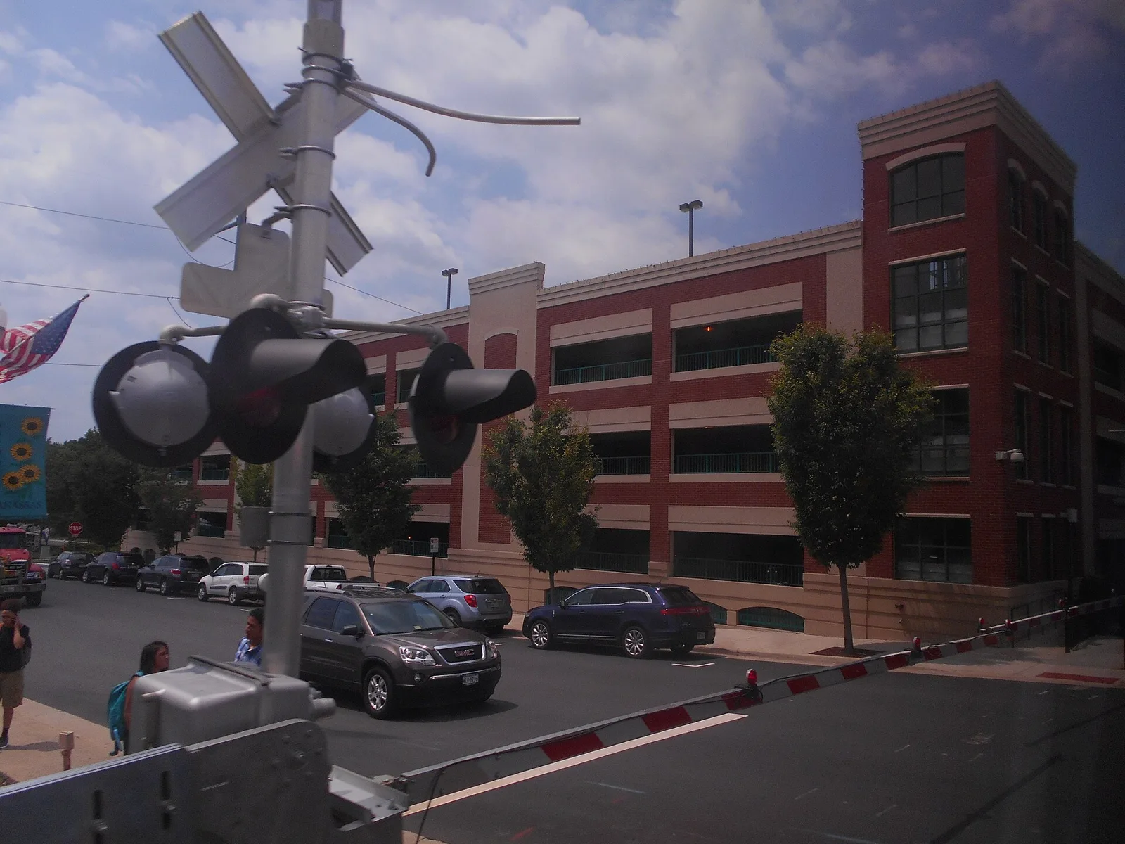 The railroad crossing by the Manassas train depot, with the downtown parking garage behind, where Santa arrives by train for Santa Lights Manassas.