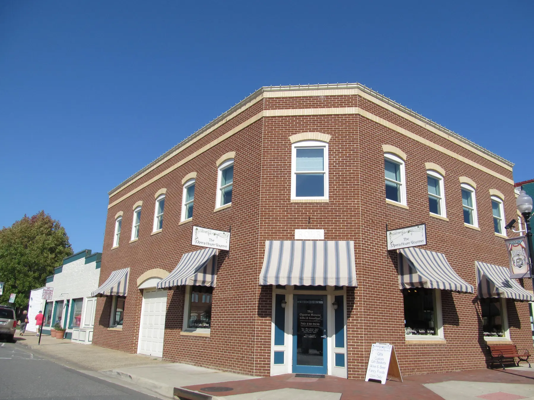 A brick storefront building with striped awnings in Historic Downtown Manassas.