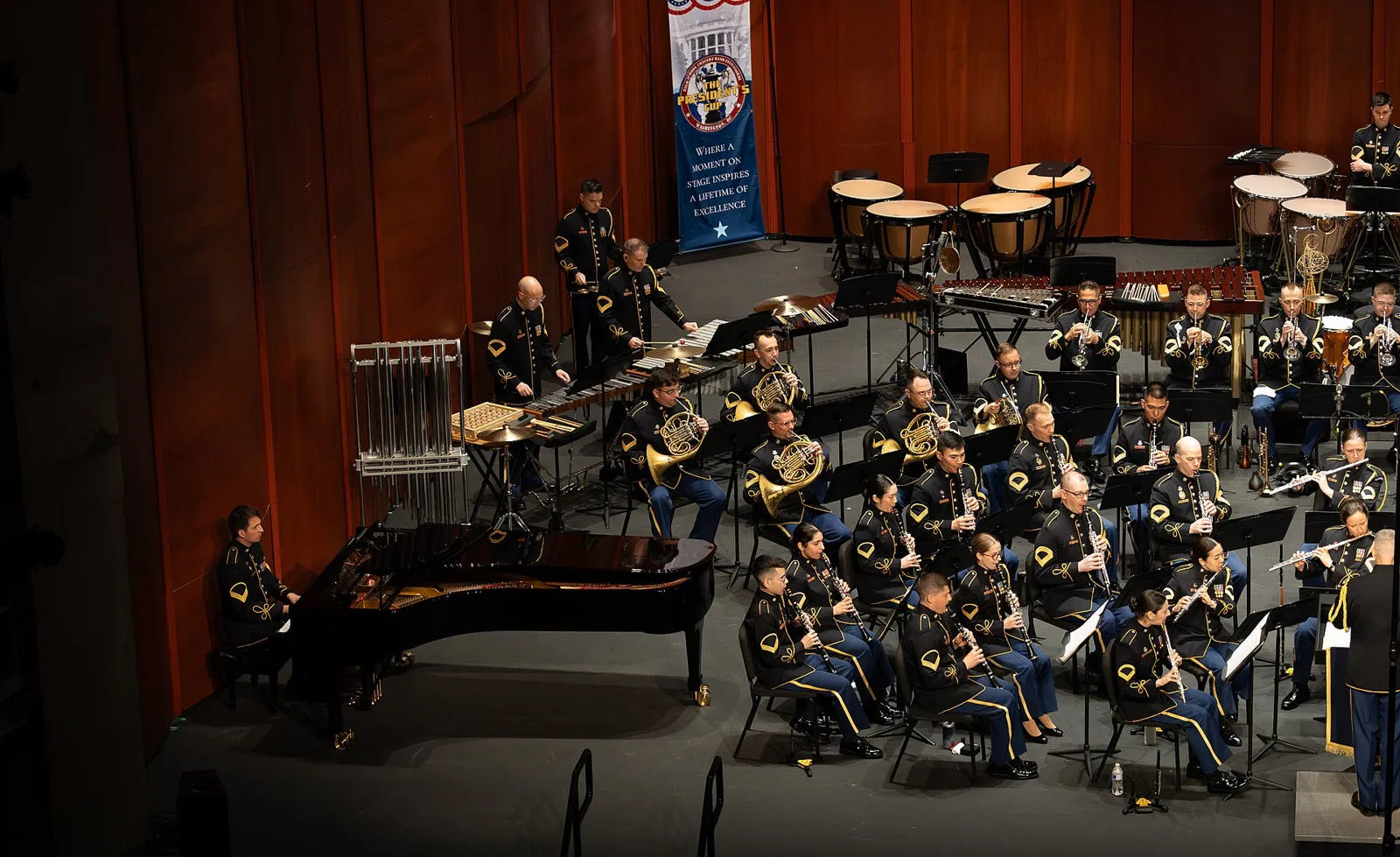 A concert band on the stage of the Hylton Performing Arts Center in Manassas.
