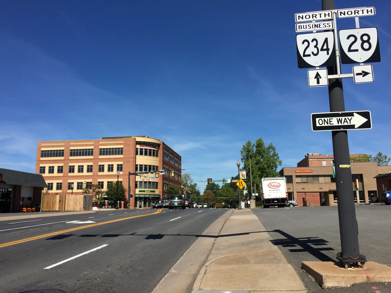 Grant Avenue (Route 234 Business) at Center Street in downtown Manassas, looking north past office and bank buildings.