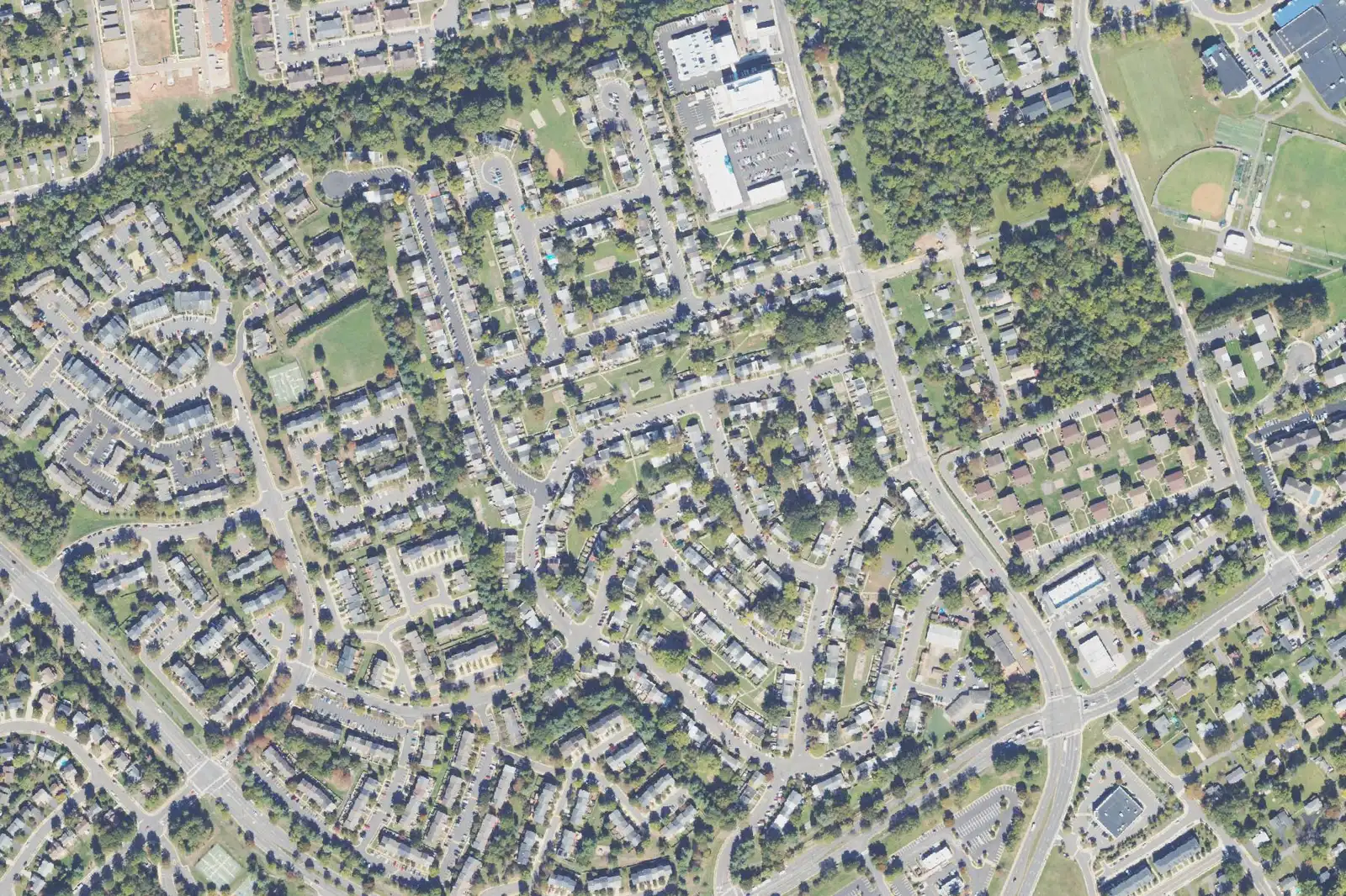 An aerial view of Georgetown South in Manassas, with rows of townhouses on looping streets between Grant Avenue and Wellington Road.